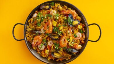 Paella de frutos do mar em fundo amarelo, imagem de abertura das tendências do foodservice