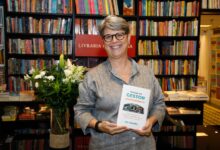 Ro Gouvêa segurando o livro Manual do Gestor Gastronômico na Livraria da Travessa