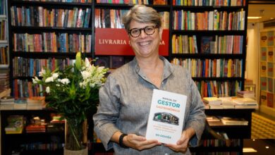 Ro Gouvêa segurando o livro Manual do Gestor Gastronômico na Livraria da Travessa