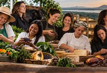 Mulheres produtoras de hortaliças, café, queijo, cacau e vinho reunidas em uma mesa de ingredientes